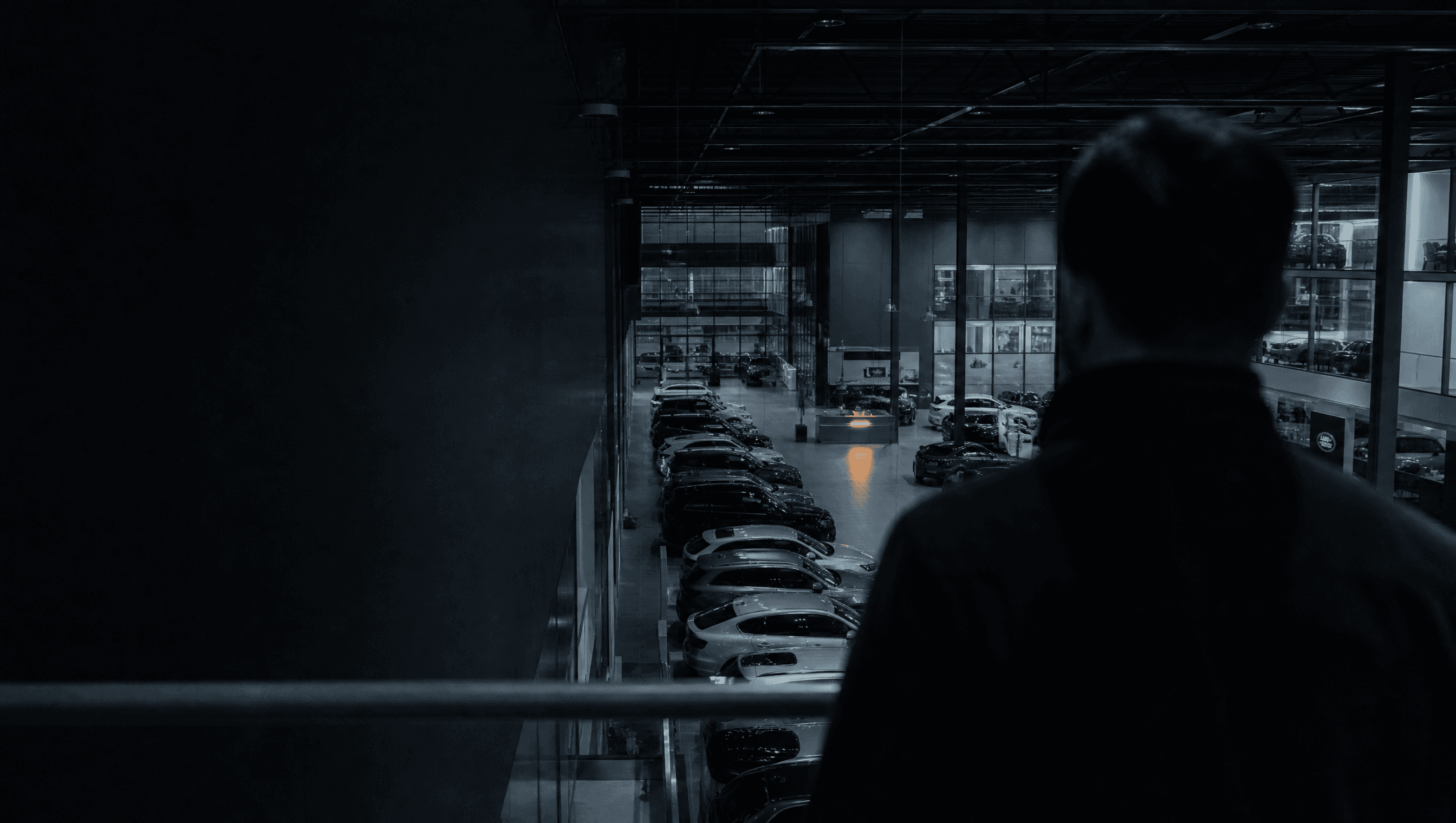 Una persona osserva dall'alto le vetture esposte in concessionaria